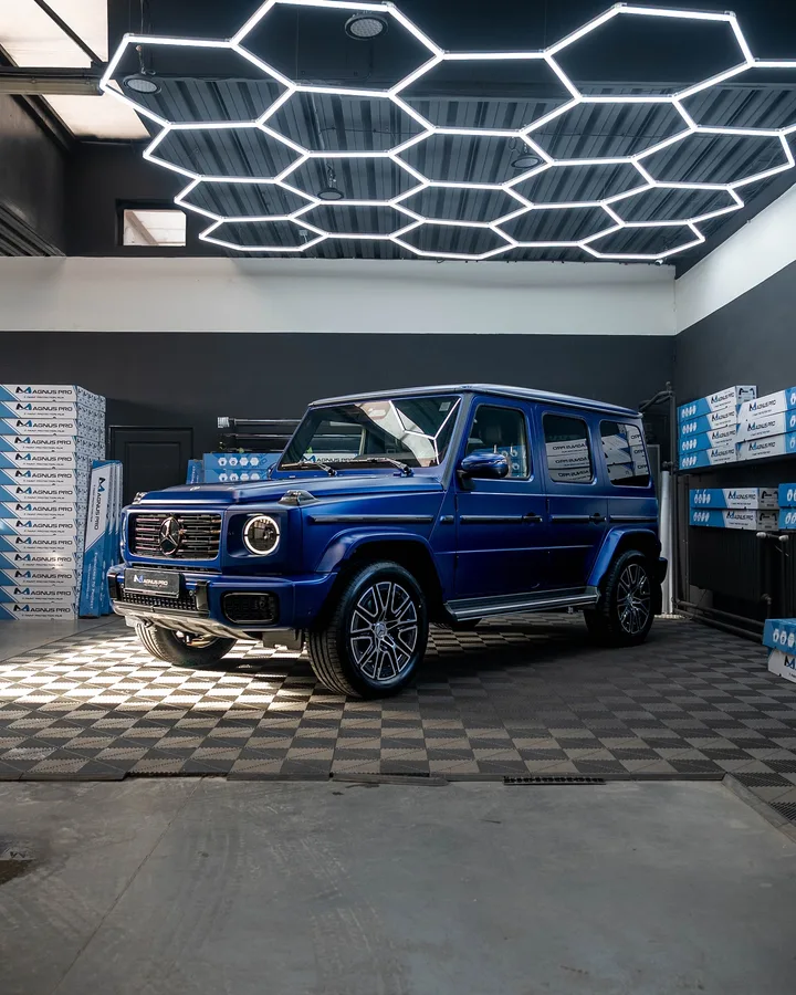 Modrý Mercedes-Benz G450d s matnou fóliou spredu z boku