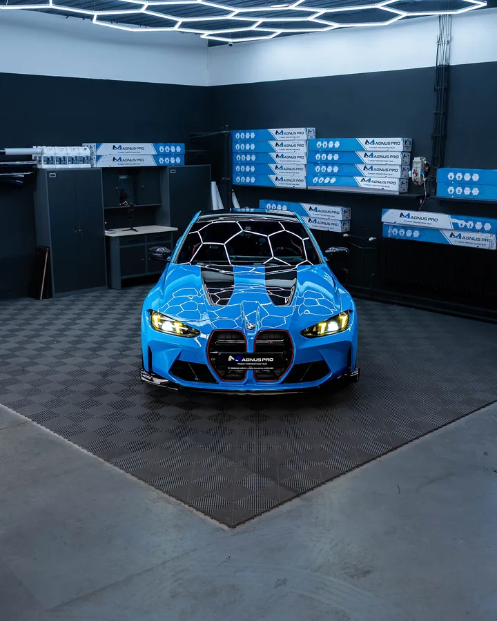 Modré BMW M4 CS spredu pod šesťuholníkovým osvetlením