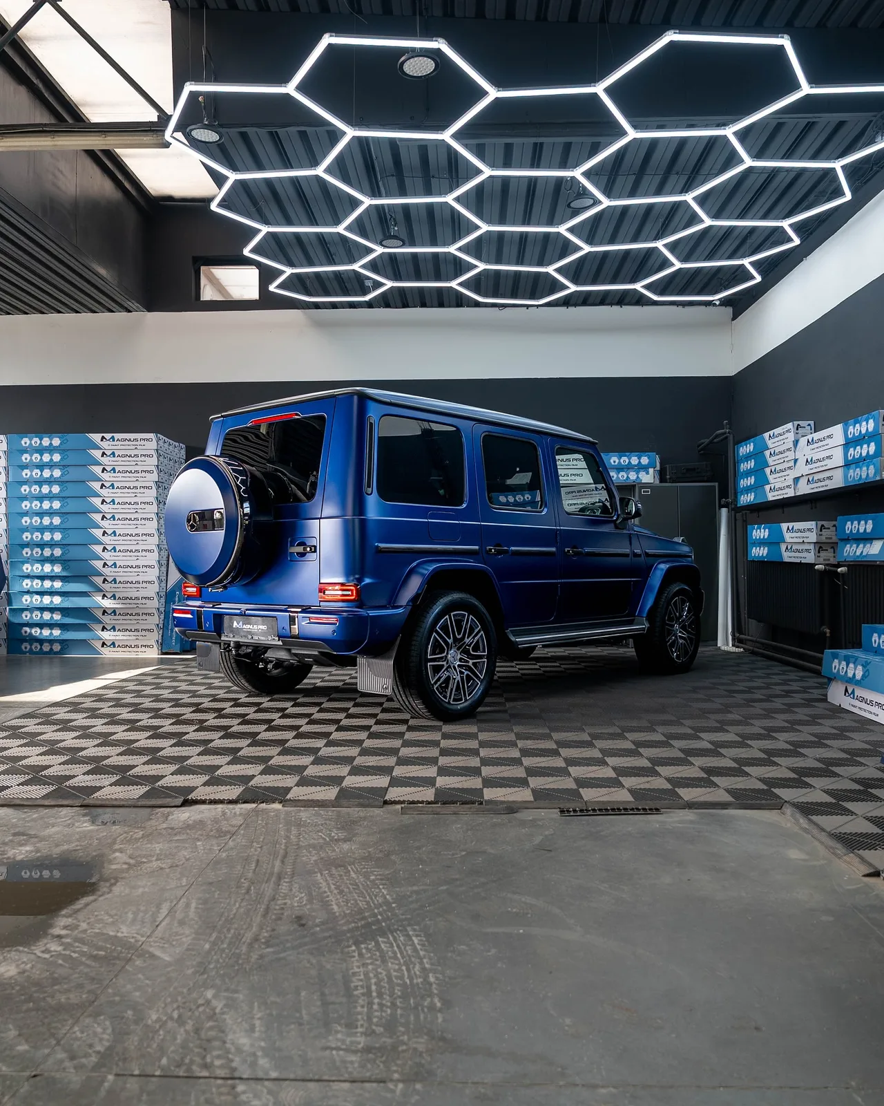 Modrý Mercedes-Benz G450d z boku zozadu s matnou fóliou Magnus Pro Matte v aplikačnom centre